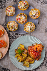Salad with crabs and pineapples in tartlets on a plate decorated with cilantro