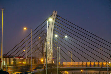 Obraz premium road bridge over railway station during sunset late evening. modern urban architecture during sunset. bridge illumination at night. colorful sky. modern construction, urban construction
