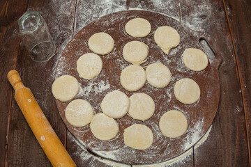round dough blanks on a wooden table on a round baking board