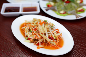 Thai food papaya salad (Som Tum) on a wooden table