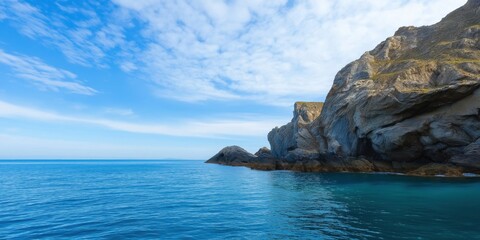 A beautiful blue ocean with a rocky shoreline. The sky is clear and the sun is shining