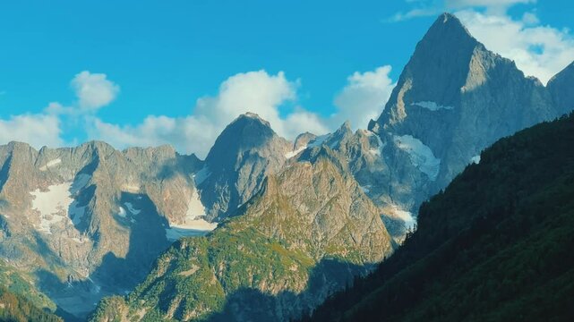Teberdinsky Nature Reserve. View of Kosygin's glade in the Gonachkhir gorge and the top of Dombai-Ulgen mountain near Lake Tumanly-Kel on a sunny summer day. Panoramic landscape. Resort. 4K