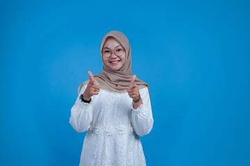 Happy woman giving thumbs up on blue background