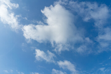 A bright blue sky with fluffy white clouds on summer
