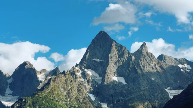 Teberdinsky Nature Reserve. View of Kosygin's glade in the Gonachkhir gorge and the top of Dombai-Ulgen mountain near Lake Tumanly-Kel on a sunny summer day. Panoramic landscape. Resort. 4K