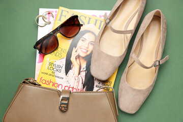 Pair of ballet flats, magazines and accessories on green background, flat lay
