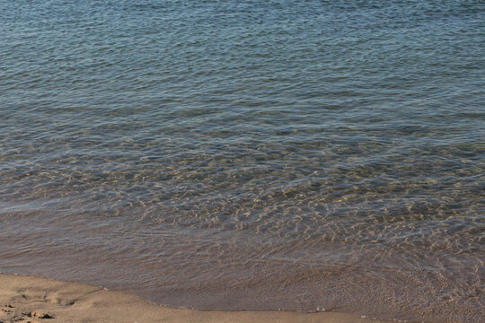 Summer vacation wavy, calm, deep blue sky, mountains, thin white clouds not visible, clear weather. boat, dinghy, rowboat far away. yellow shiny brown sea sand on shore beach. Balıkesir, Sarimsakli