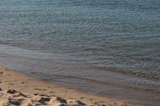 Summer vacation wavy, calm, deep blue sky, mountains, thin white clouds not visible, clear weather. boat, dinghy, rowboat far away. yellow shiny brown sea sand on shore beach. Balıkesir, Sarimsakli
