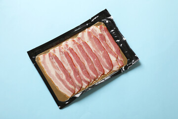 Pack of bacon on light blue background, top view