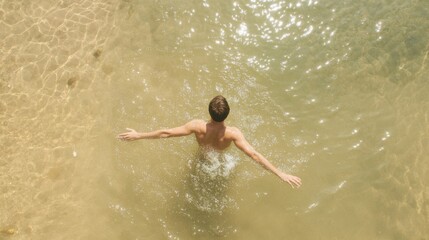 Fototapeta premium Man swimming in shallow water, sunny beach