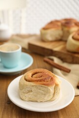 Freshly baked cinnamon roll on wooden table, closeup