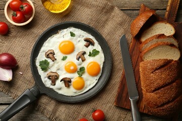 Tasty fried eggs with mushrooms and parsley served on wooden table, flat lay