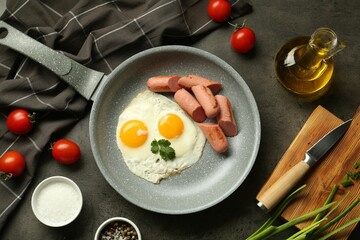 Tasty fried eggs and sausages served on grey table, flat lay