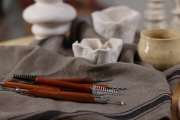 Naklejka premium Set of different clay crafting tools and pottery on table, closeup