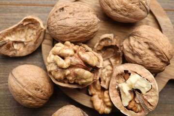 Fresh walnuts with shells on table, flat lay