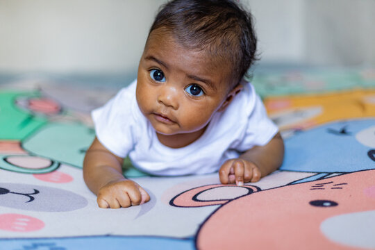 A little girl doing tummy time, a little girl. Newborn premature baby. Tummy time is fun time. African baby, African girl, black baby, Brazilian baby.