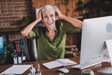 Photo of glad positive cheerful lady dressed shirt eyewear workplace workstation loft interior...