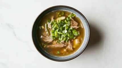 A bowl of Korean seolleongtang (ox bone soup) with green onions on a clean white surface.