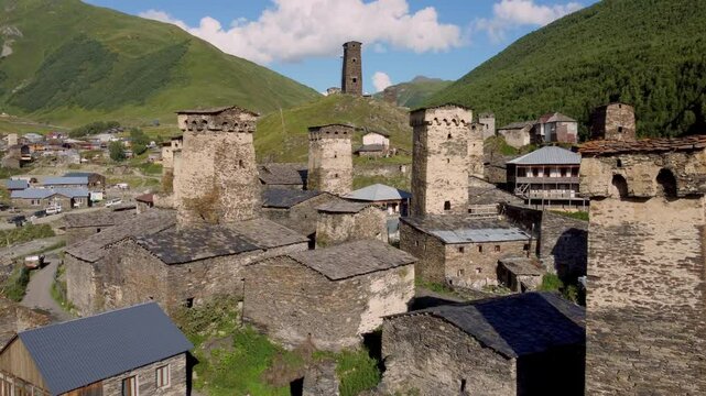 Majestic stone towers and traditional houses stand against lush green of mountains in Ushguli, Svaneti, Georgia, UNESCO World Heritage Site Drone Footage.