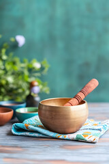 A serene setting for a sound healing session, featuring a large golden singing bowl resting on a soft cushion, surrounded by smaller bowls of different tones