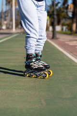 Low section of active senior woman wearing inline skates standing on bike lane
