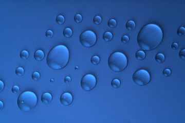 Macro drops of water or liquid cosmetics gel on dark blue background