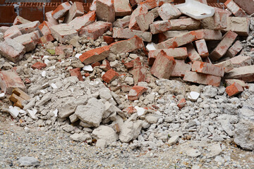 A pile of broken bricks and construction debris lies scattered on the ground, suggesting demolition or renovation work