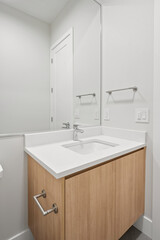 A bathroom sink with a wooden cabinet underneath