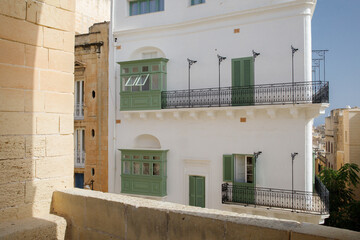 White and olive colored traditional house facade in the center of Valletta the capital of Malta
