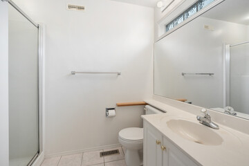 A bathroom with a white toilet, sink, and mirror