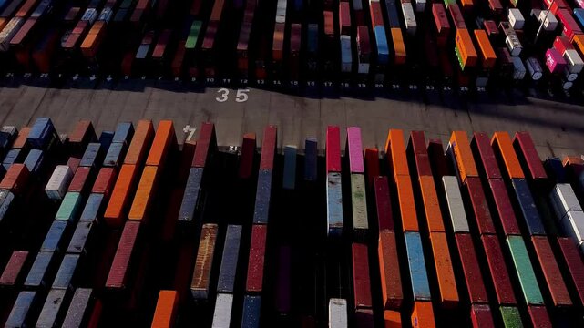 Aerial view of shipping containers and cargo ships in the sea port. Concept of sea and maritime trade and trade war due to tariffs. Commercial hub