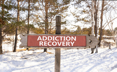 Addiction recovery symbol. Concept words Addiction recovery on beautiful wooden road sign. Beautiful snow forest background. Psychology addiction recovery concept. Copy space.