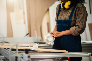African American craftswoman using equipment in a wood factory, engaged in professional carpentry and furniture making, representing female empowerment in the skilled trades