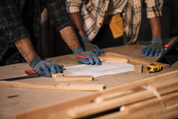 Two experienced male carpenters collaborating in a woodworking factory, crafting high-quality furniture and woodwork with precision and skill, showcasing teamwork and professional craftsmanship.