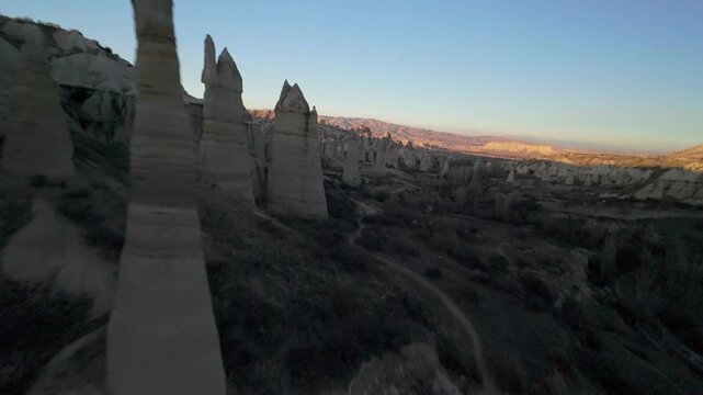 FPV Drone Circling and Flying Between Chimney Like Spires and Phallic Rock Formations in Love Valley