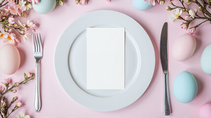 Elegant Easter dining table setting with blank white menu mockup laying on plate. Pastel pink eggs and spring flowers, top view. Restaurant invitation card template, mock up with copy space