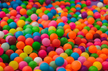 Background of many plastic colorful round balls in children's playroom for kids. Photography, childhood concept.