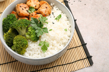 Tasty rice with broccoli, chicken and parsley on grey table, closeup