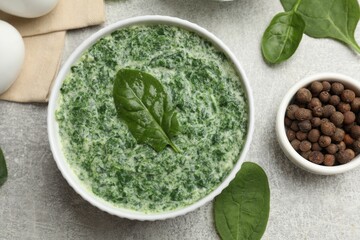 Delicious spinach sauce served on grey table, flat lay