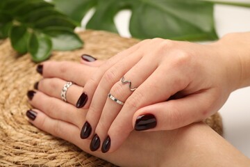 Fototapeta premium Woman wearing beautiful rings at white table, closeup