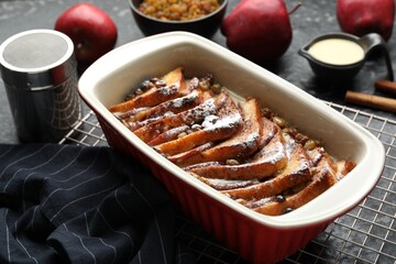 Freshly baked bread pudding in baking dish on grey table, closeup