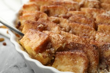 Delicious bread pudding with raisins and cinnamon on table, closeup