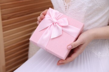 Bride with beautiful wedding gift indoors, closeup. Space for text