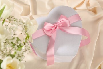 Beautiful wedding gift and flowers on silk fabric, above view