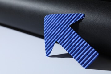 One blue paper arrow on color background, closeup