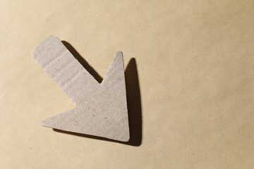 One paper arrow on kraft background, top view. Space for text