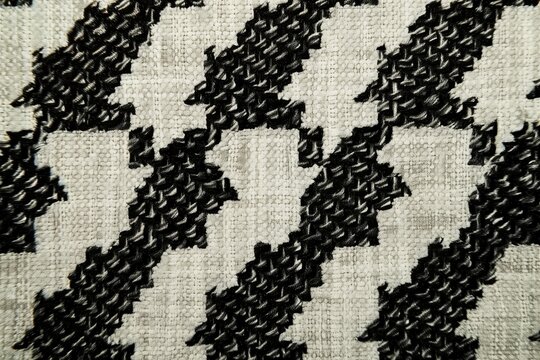 A close-up of the houndstooth pattern on fabric, highlighting its intricate and geometric design.