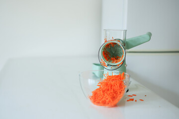 Small blue electric household appliances for raping and cutting vegetables photographed on white...