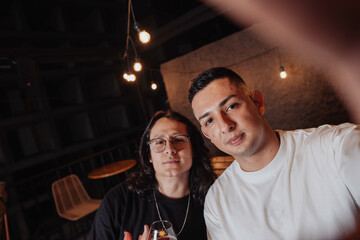 Smiling Latin friends POSING FOR PHOTO IN A BAR