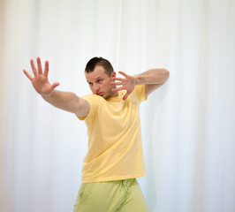 Male choreography in motion in the studio. Young man dancing in a dance studio